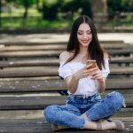 Девушка переписывается и улыбается
